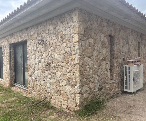 Angle de maison en pierre avec groupe de climatisation extérieur – NATB