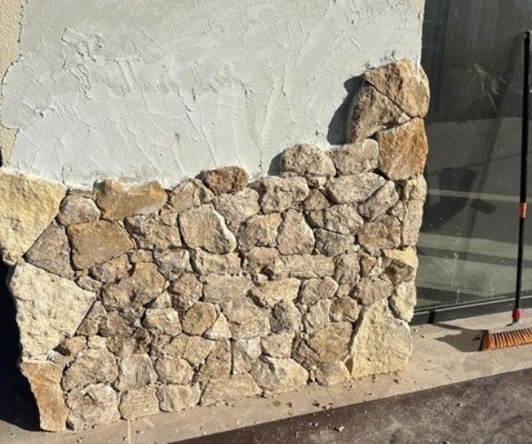 Chantier de pose de parement en pierre naturelle sur mur extérieur – NATB