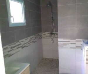 Salle de bain avec douche italienne et carrelage décoratif en pierre – NATB