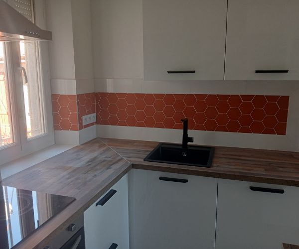 Cuisine rénovée avec crédence en carrelage hexagonal orange et plan de travail bois – NATB