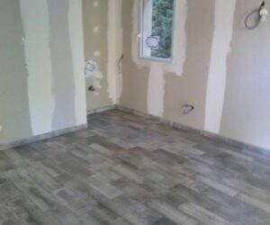 Pose de carrelage imitation bois dans une pièce en rénovation – NATB