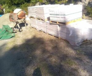 Matériaux de construction et bétonnière sur un chantier extérieur – NATB