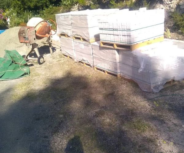 Matériaux de construction et bétonnière sur un chantier extérieur – NATB