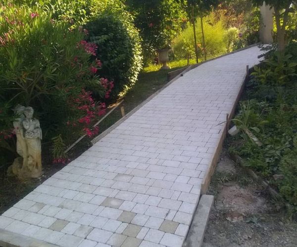 Allée en pavés reconstitués entourée de végétation – NATB
