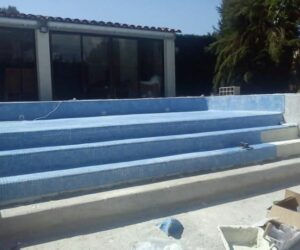 Pose de mosaïque bleue sur les escaliers d’une piscine en rénovation – NATB