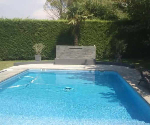Piscine rénovée avec mur décoratif en carrelage imitation bois – NATB