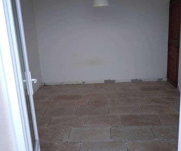 Pose de carrelage en pierre naturelle dans une pièce intérieure – NATB