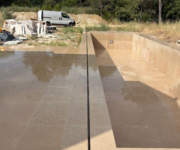 Détail de finition entre margelle et mur béton