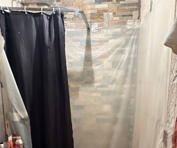 Salle de bain rénovée à Marseille avec douche à l’italienne vitrée, meuble vasque moderne et carrelage mural blanc