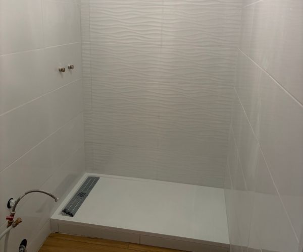 Ancienne salle de bain avant rénovation à Marseille avec douche vétuste et revêtements anciens