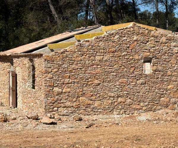 Angle de maison en pierre naturelle avec échafaudage – travaux de maçonnerie extérieure