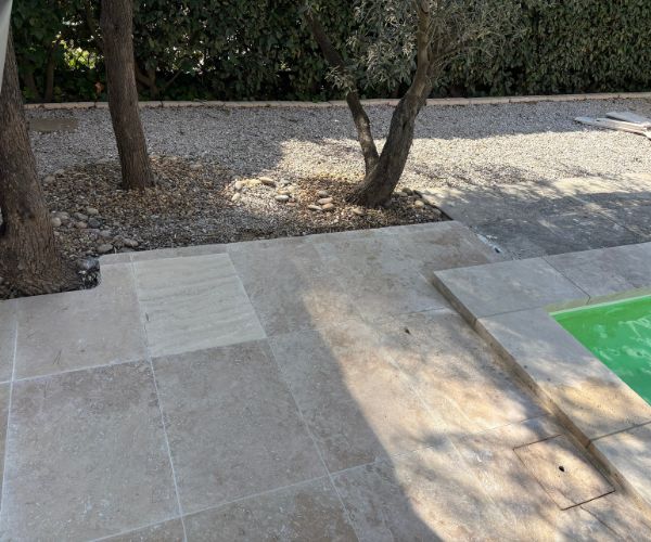 Terrasse en travertin avec transition vers jardin et gravier
