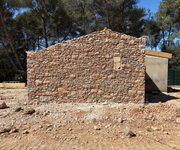 Maison en pierre naturelle en cours de construction avec bétonnière – chantier de maçonnerie à Marseille