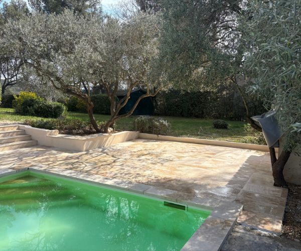 Terrasse en travertin avec piscine et jardin paysager
