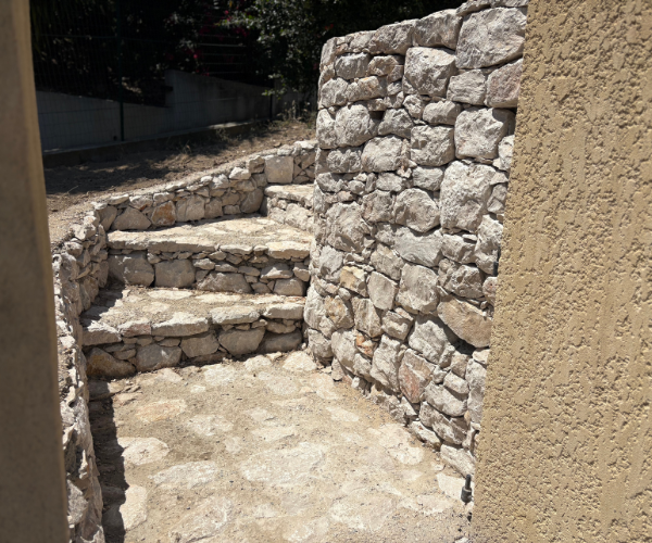 Mur de soutènement arrondi en pierre calcaire de carrière avec escalier en pierre naturelle réalisé à Marseille.